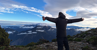A Warwick student standing on a mountain