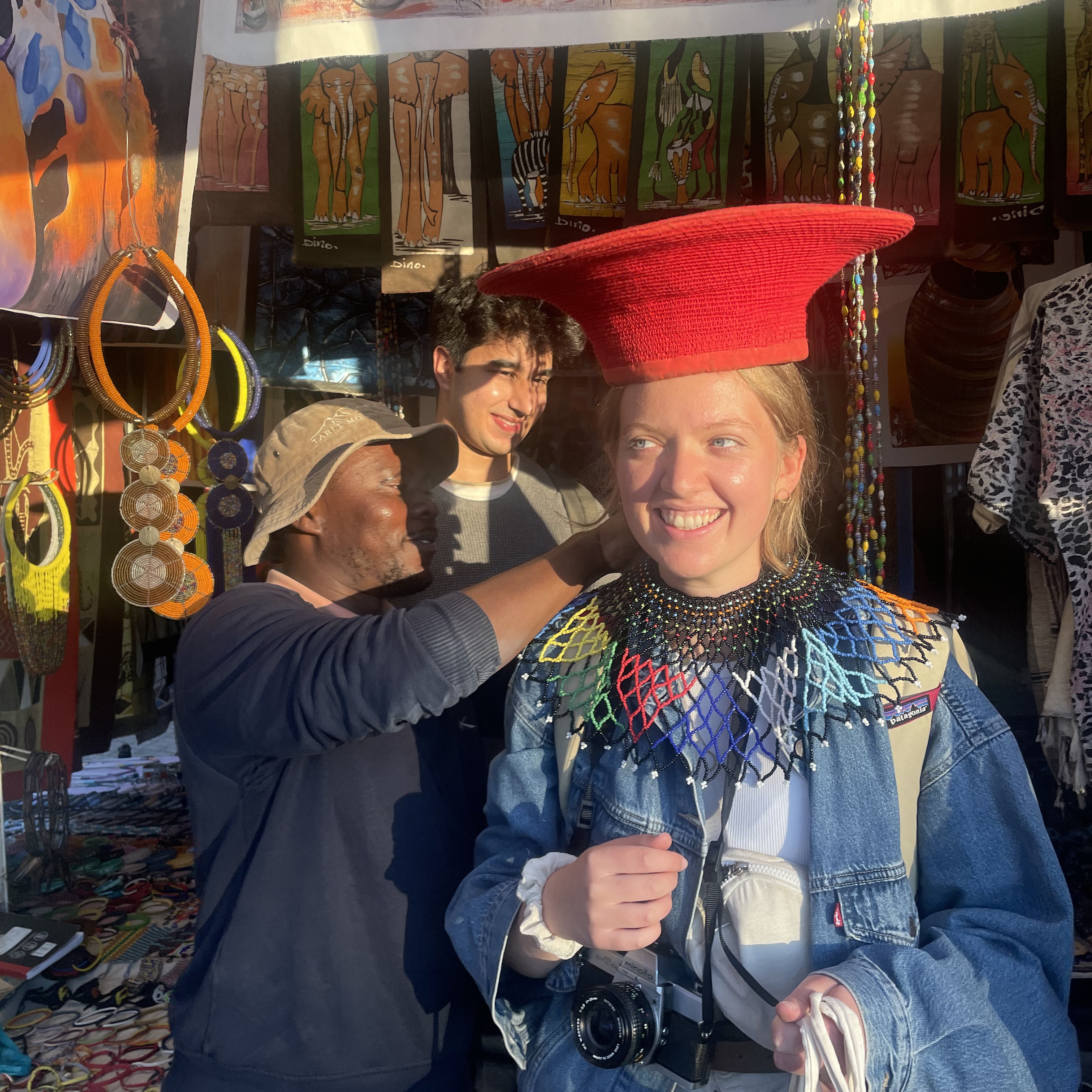 Student being dressed in traditional outfit at African market
