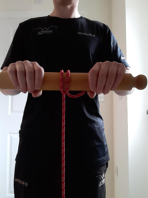 Hands holding narrow roller with rope wound down