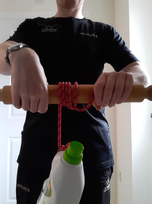 Hands holding narrow roller with rope wound up