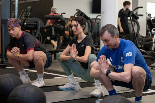 three people train in the gym