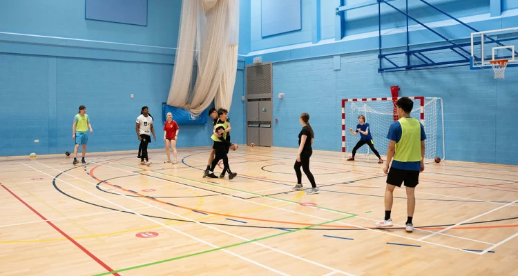 Group of people playing indoor handball in the Sports and Wellness Hub