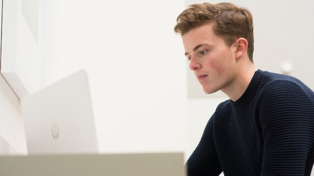 Student on his computer in the Oculus, at Warwick