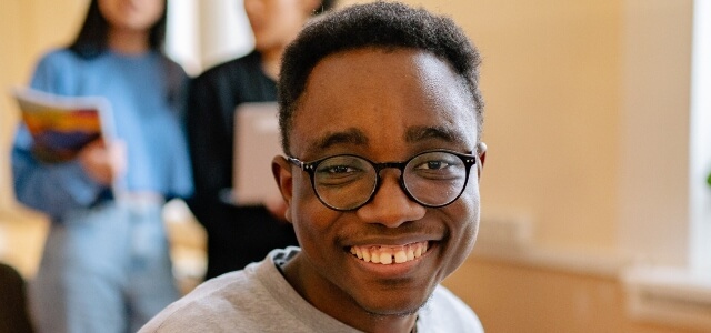 Student in the library smiling at the camera