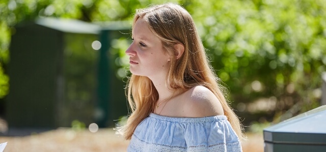 Student outdoors enjoying the sunshine, at Warwick