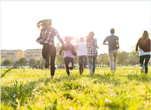 A group of people run through a meadow