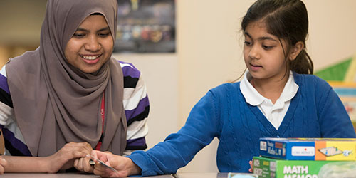 A student helping a school child