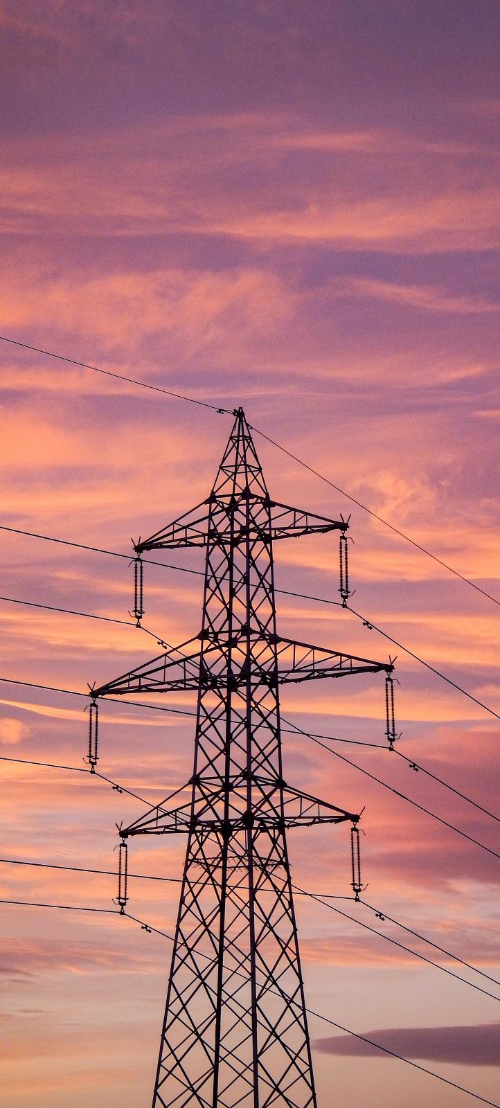 Image of a sunset with a black outline of a electricity tower