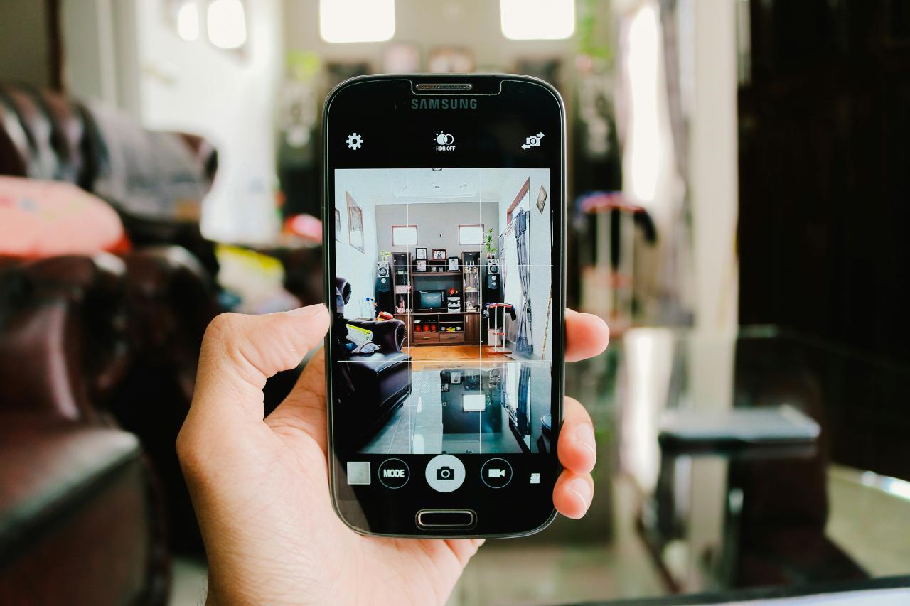 A person taking a picture of inside their house, showing just their hand and the phone