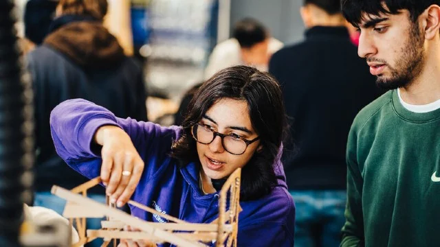 Two students working together on a model
