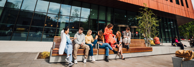 This image shows a group of students socialising outside of the Faculty of Arts building on the University of Warwick campus