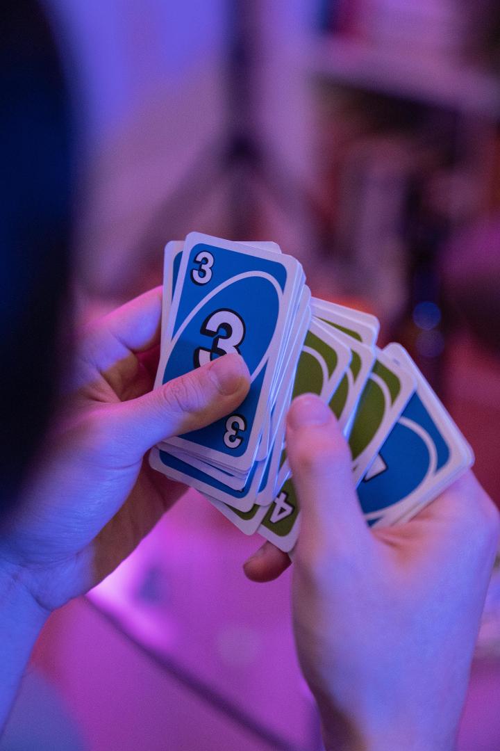 Student holding Uno cards at Games Hub