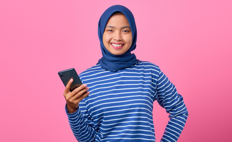 A smiling woman holding a phone 