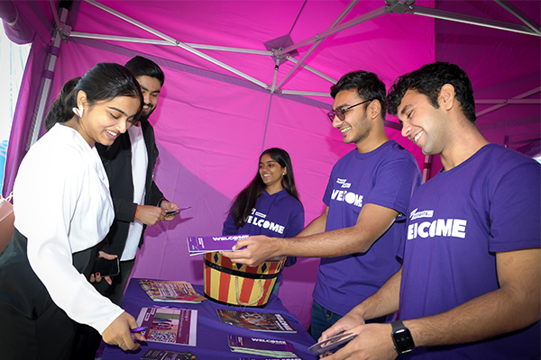 Three student helpers offer advice to two new students.