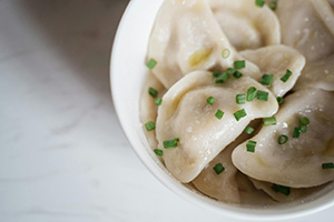 Steamed dumplings served with chopped chives