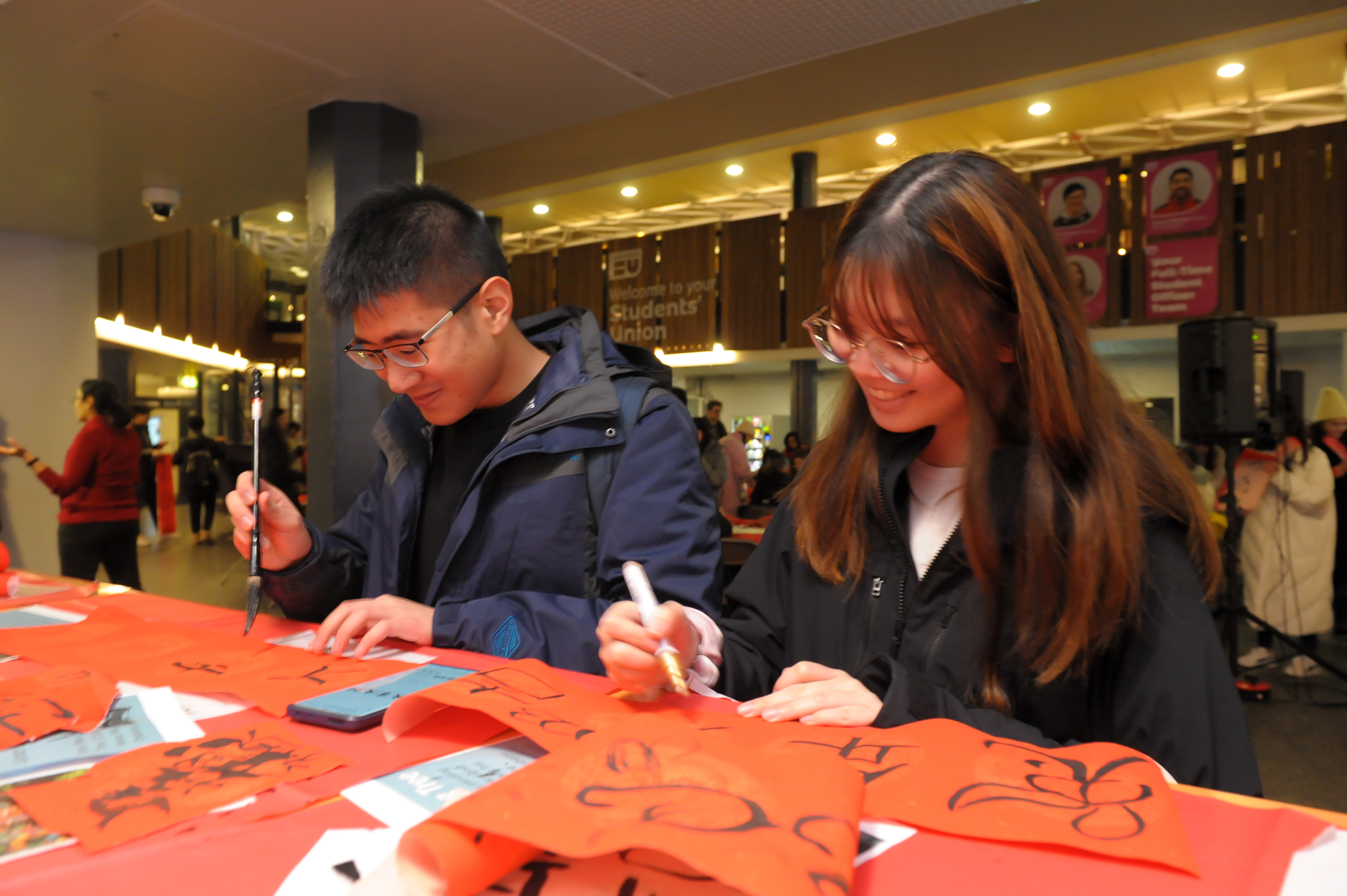 Two students are having a go at Calligraphy