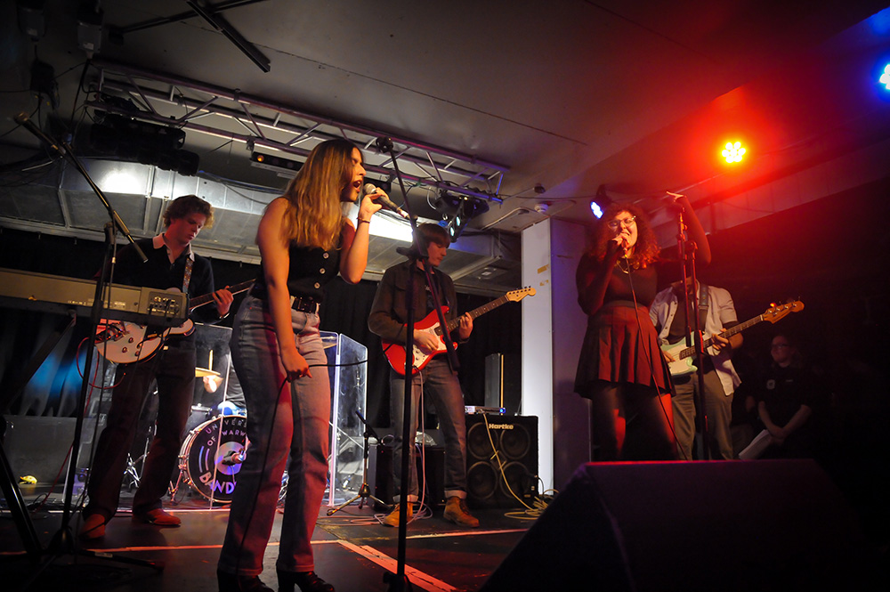 A group of students on stage performing at the Copper Rooms