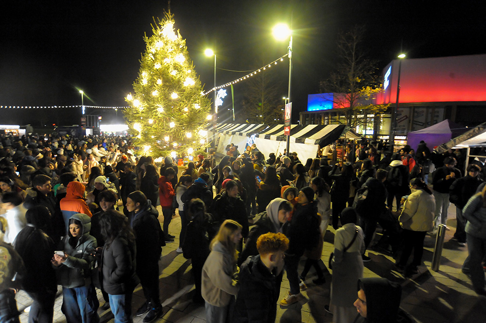 The Christmas Tree sparkling on the Piazza, surrounded by people and the Christmas Market.