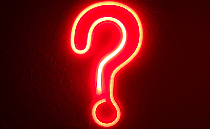A neon red question mark shaped sign