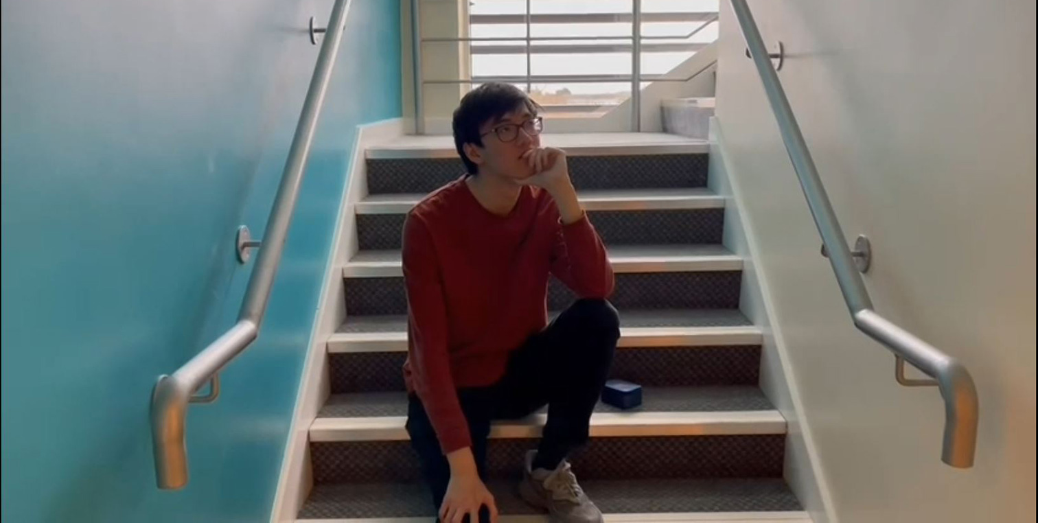 A man sits contemplating on a staircase.