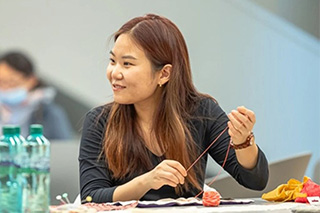 Woman holding thread at a craft event