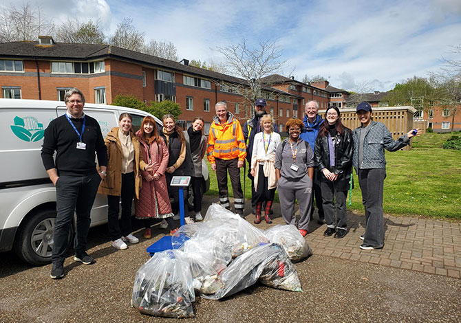 A group of staff and students pose with the rubbish they have collected on a litter pick