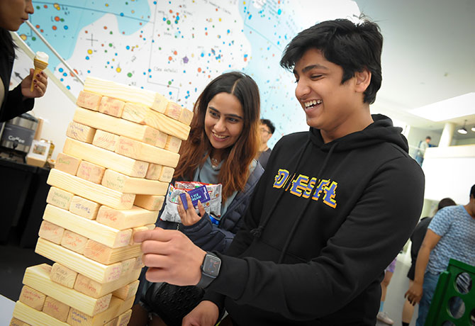 Two students smile as they play giant jenga