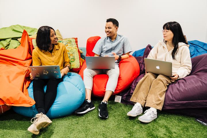 three students chatting on beanbags