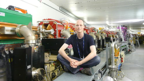 A photo of Chris Bloomer sat inside the Diamond Light Source accelerator tunnel.