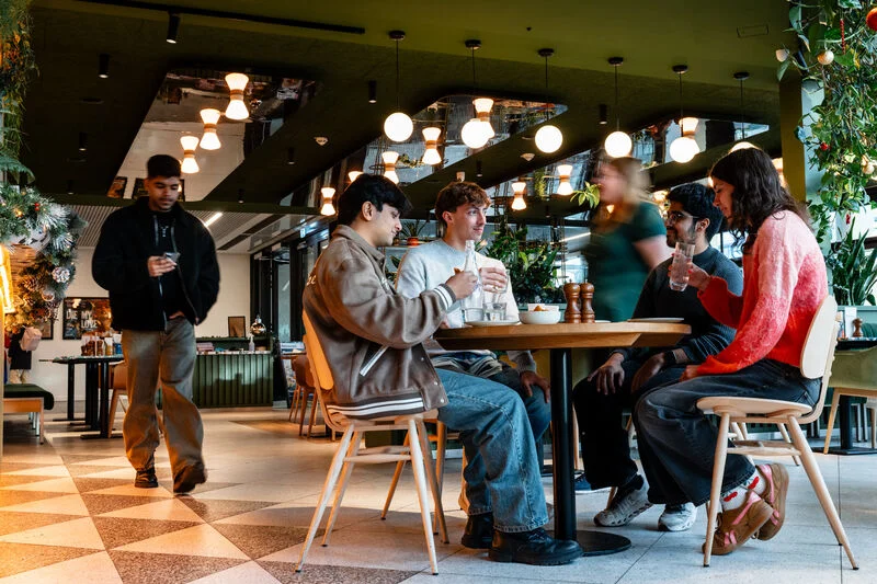 A group of students having a friendly discussion in a cafe