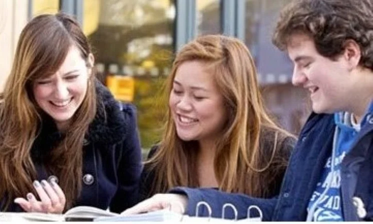 Three students looking at a book
