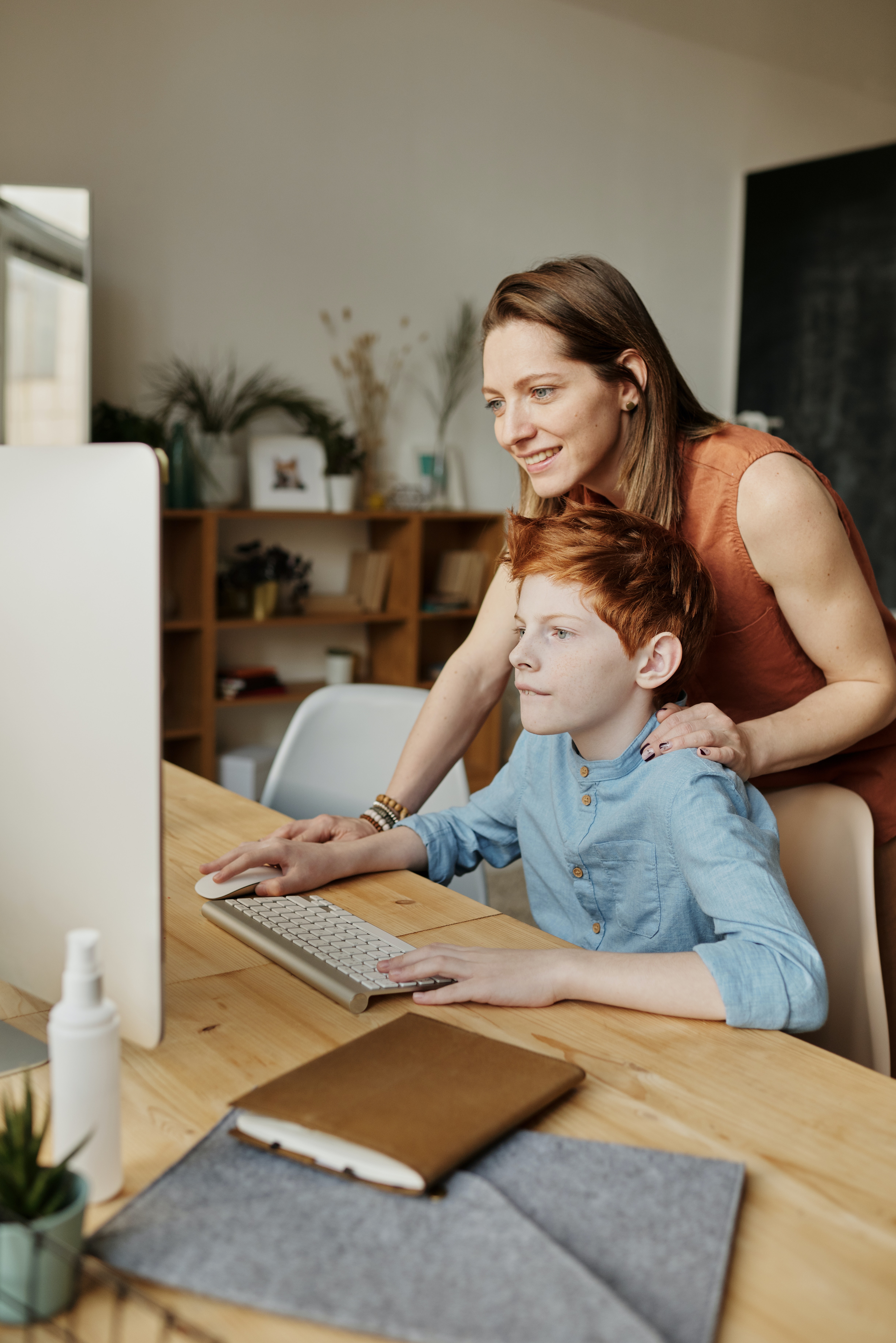An adult working with a child on a computer