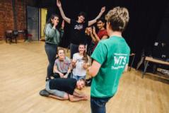 Group of students in a theatre room doing improv