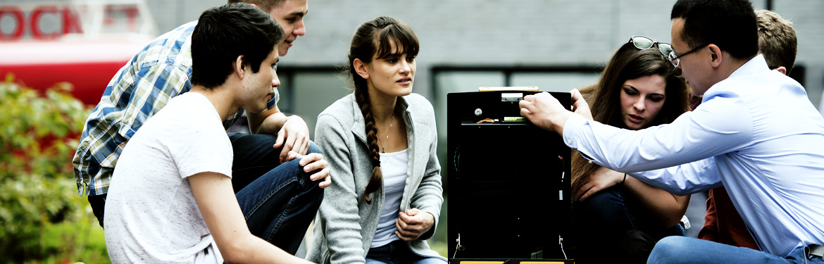 This image shows a cohort of students exploring a desktop computer