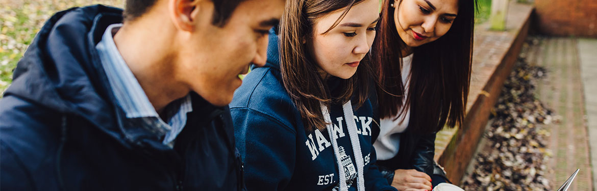 Global Education and International Development students researching on a laptop outside