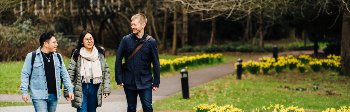 Students of World Literature at the University of Warwick engaged in cheerful conversation while strolling in nature