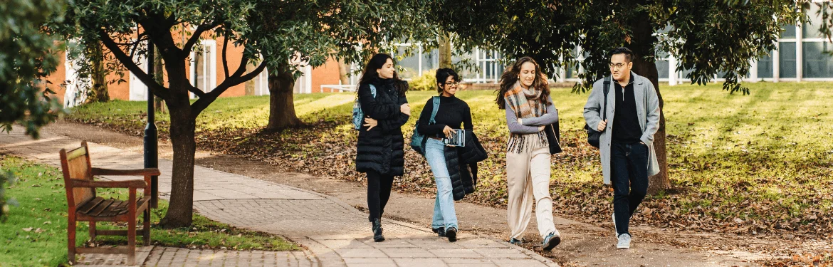 Four students walking through campus discussing Law.