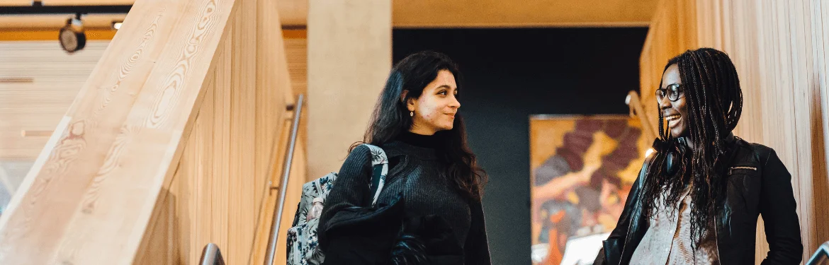 Two students in a contemporary university building discussing Law.