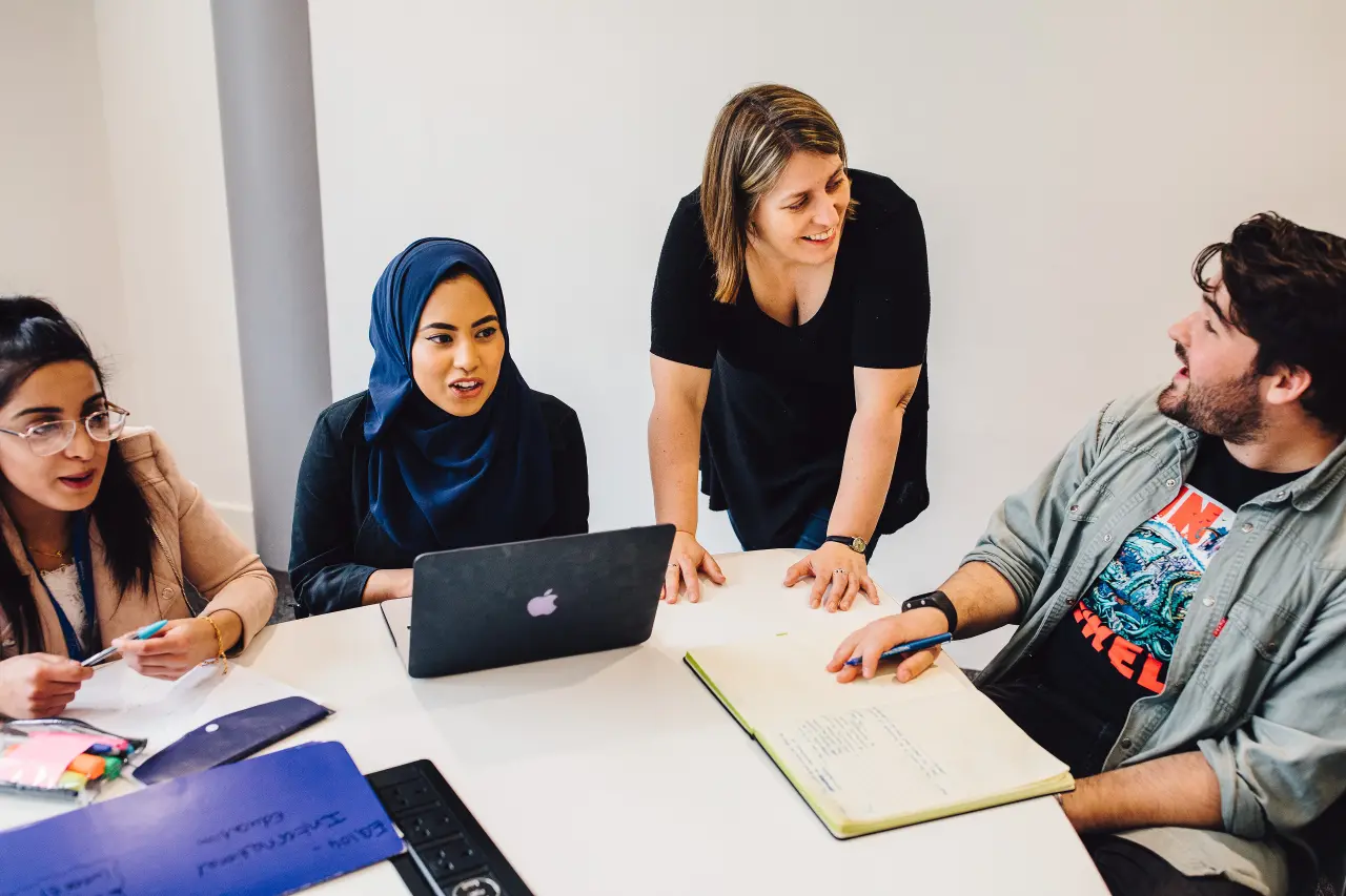 Students working with each other around a table with their Education Studies tutor at University of Warwick.