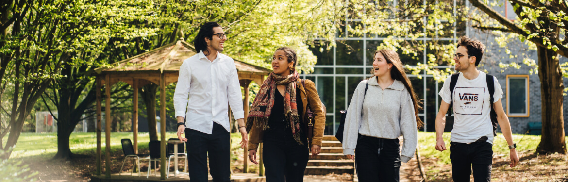 Environmental Humanities students engaged in cheerful conversation while strolling in nature