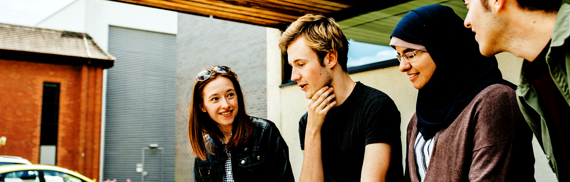 This image shows a diverse group of Film and TV students conversing outside