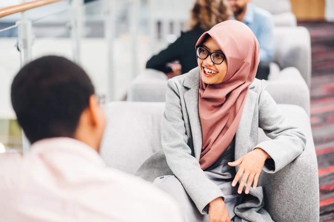 Postgraduate students chatting to each other in a relaxed setting at University of Warwick.