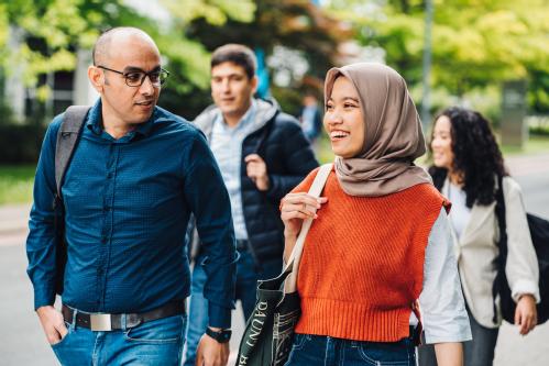 A group of students walking and talking on campus