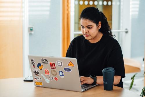 A student working at a laptop covered in stickers