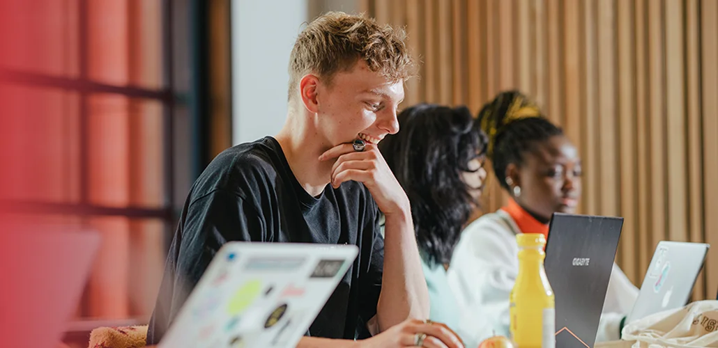 student working on a laptop on campus