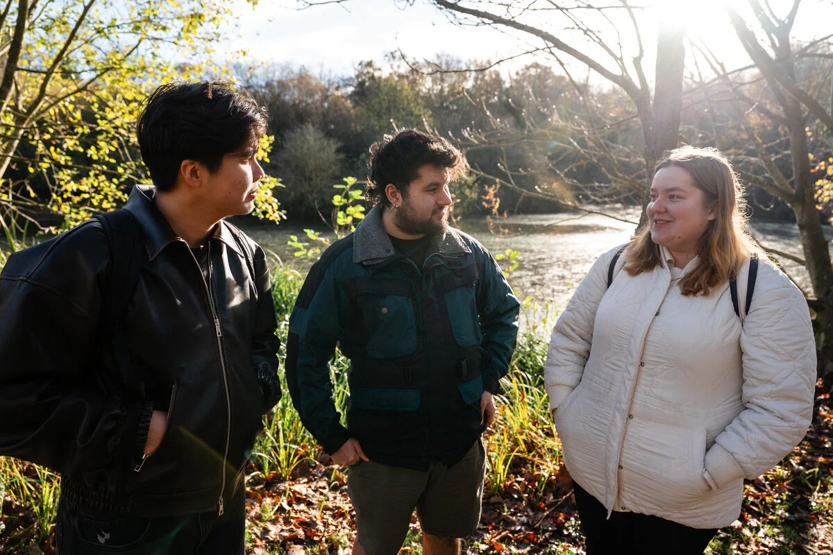 Three people talking together in an outdoor setting.