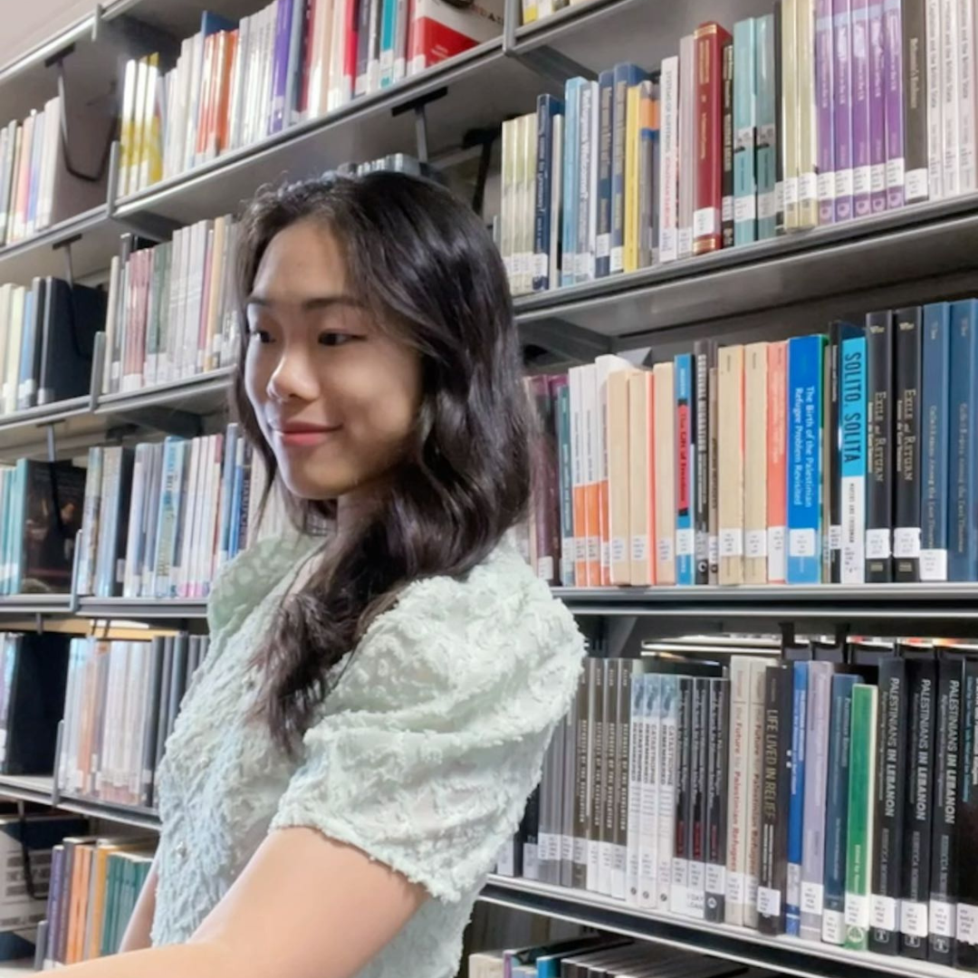 Student in front of rows of books in the library