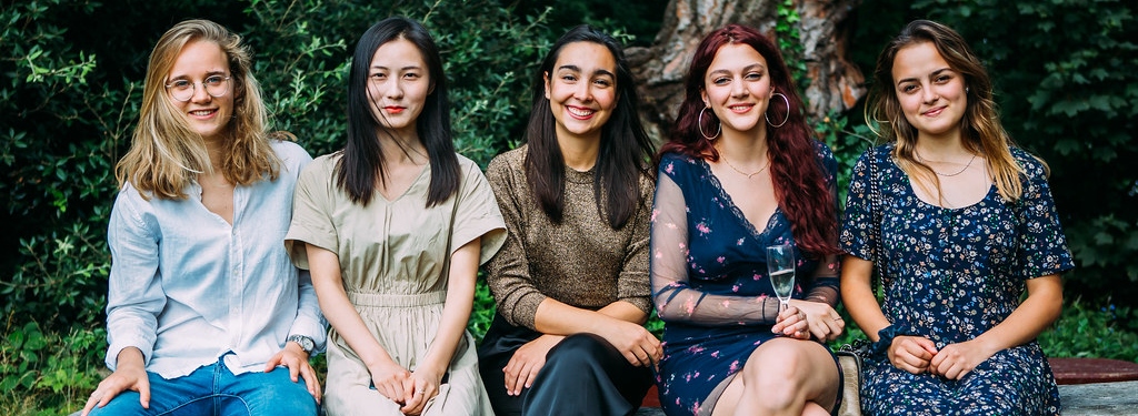 four female students sitting on a bench