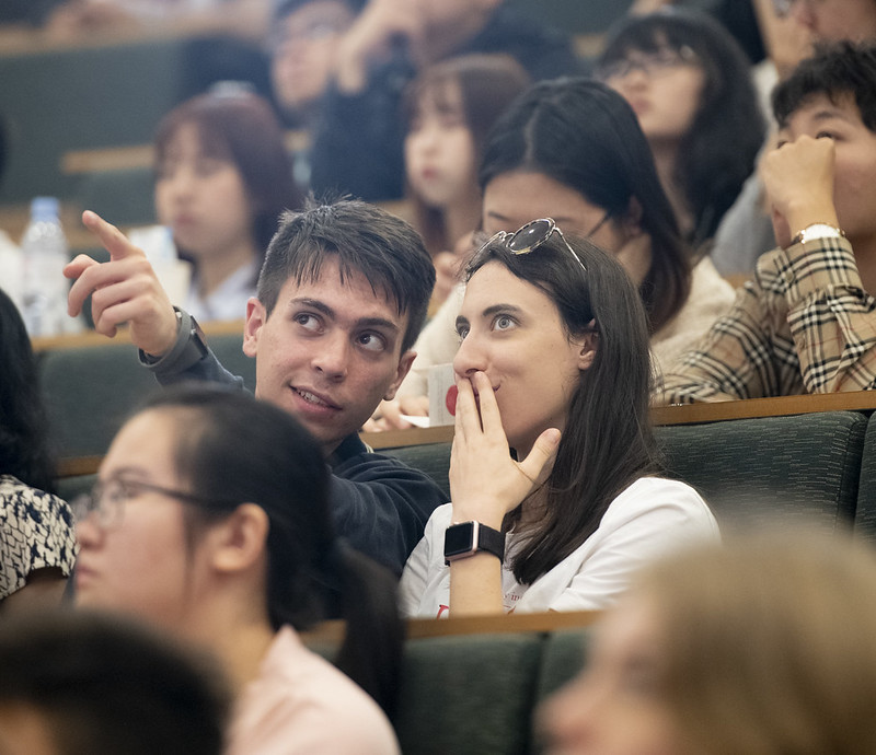 two students talking in a lecture