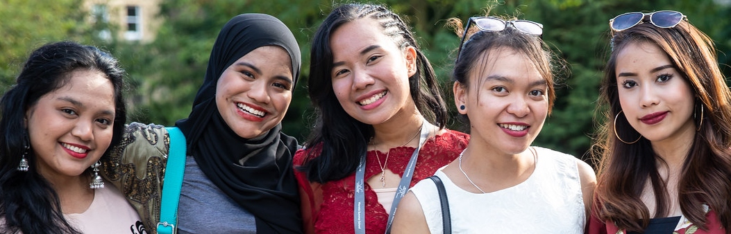 four female students standing smiling